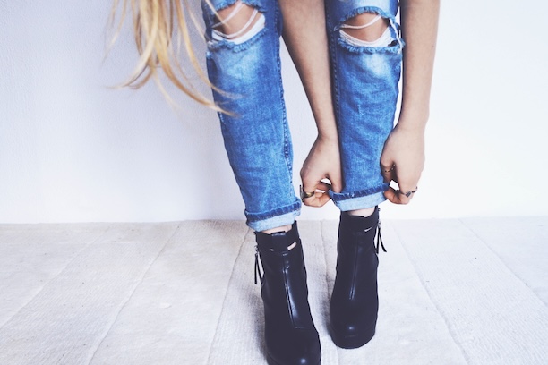 A woman pulling up her ripped jeans