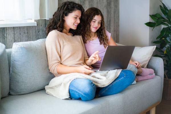mother and daughter looking at laptop together